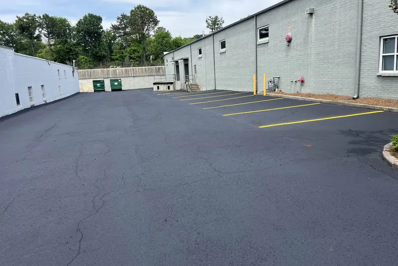 Service drive alongside a commercial building marked out with yellow stall lines and a painted kerb